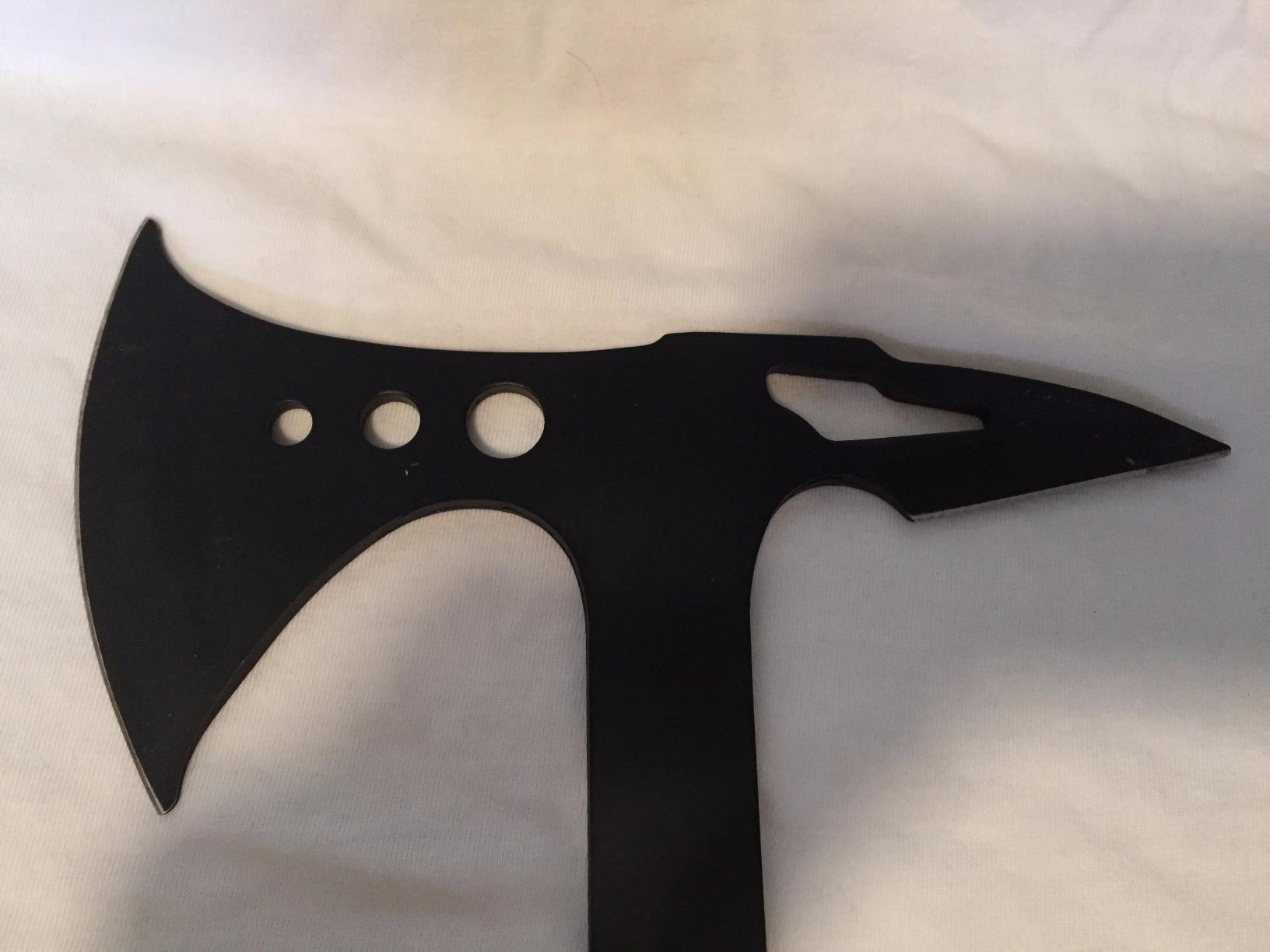 Black MTech USA axe head photographed on white fabric, showing the three lightening holes and the spike poll